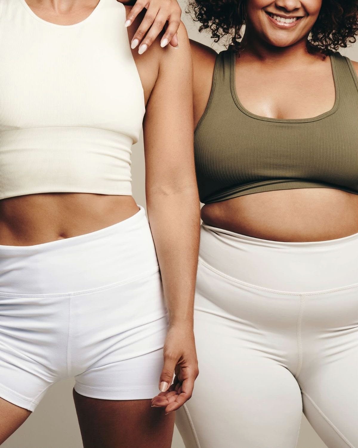 Duas mulheres sorridentes em roupa fitness, corpos reais