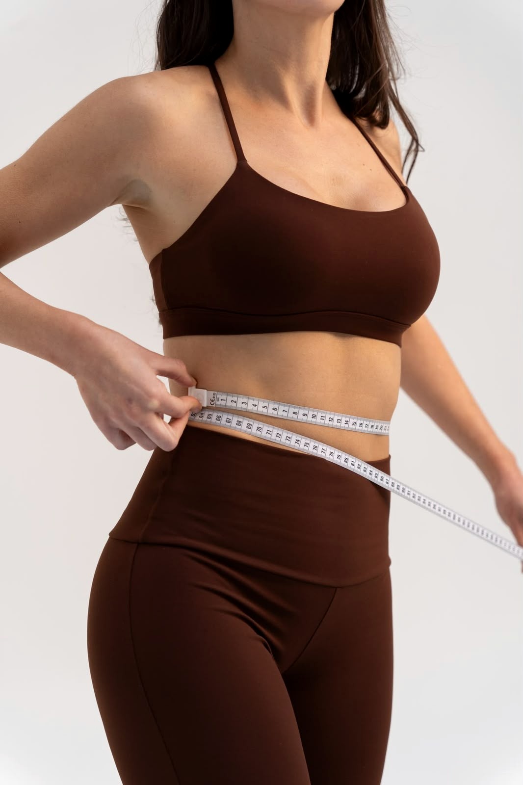 Mulher em movimento com roupa fitness marrom